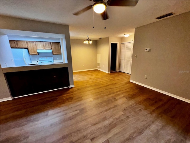 unfurnished living room with baseboards, visible vents, wood finished floors, and ceiling fan with notable chandelier