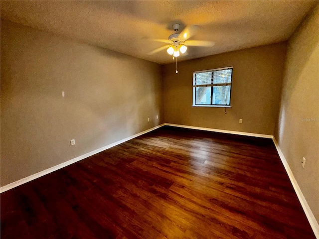 empty room featuring dark hardwood / wood-style flooring, ceiling fan, and a textured ceiling