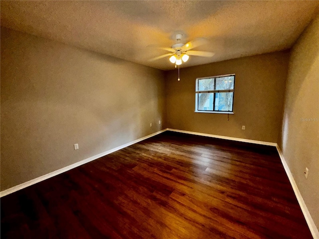 empty room with ceiling fan, a textured ceiling, baseboards, and wood finished floors