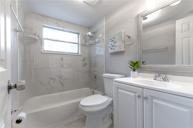 full bathroom featuring a textured ceiling, vanity, toilet, and tiled shower / bath