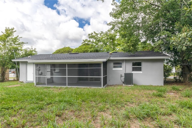 back of house featuring a sunroom, central air condition unit, and a yard