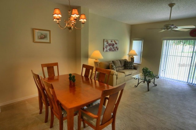 dining space with ceiling fan with notable chandelier, a textured ceiling, and light colored carpet