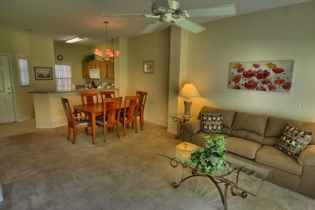 carpeted living room with a textured ceiling and ceiling fan with notable chandelier