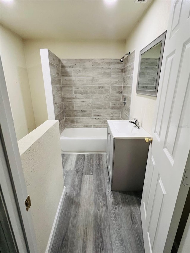 full bath featuring shower / washtub combination, wood finished floors, and vanity