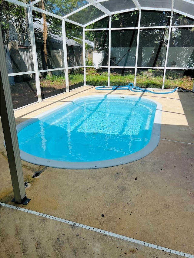 view of pool featuring fence private yard, glass enclosure, a patio area, and a fenced in pool