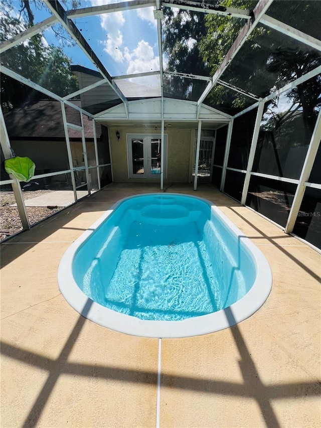 pool with french doors, a patio area, and a lanai