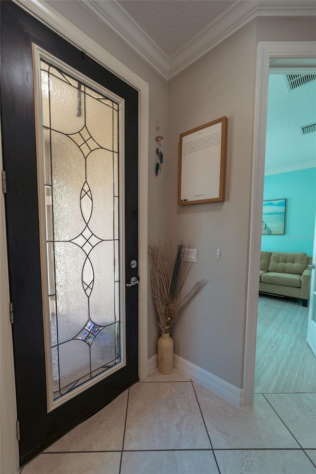 tiled entrance foyer featuring ornamental molding