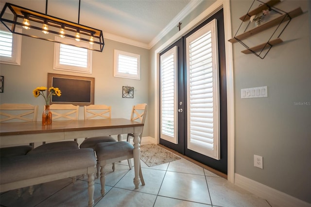 dining room with a textured ceiling, light tile patterned floors, crown molding, and french doors