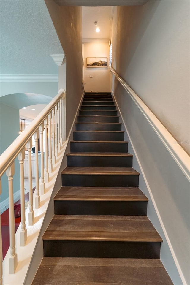 staircase featuring ornamental molding