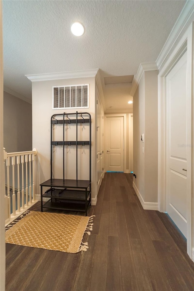 hallway featuring a textured ceiling, dark hardwood / wood-style flooring, and crown molding