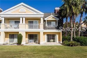 rear view of property featuring a lawn and a balcony