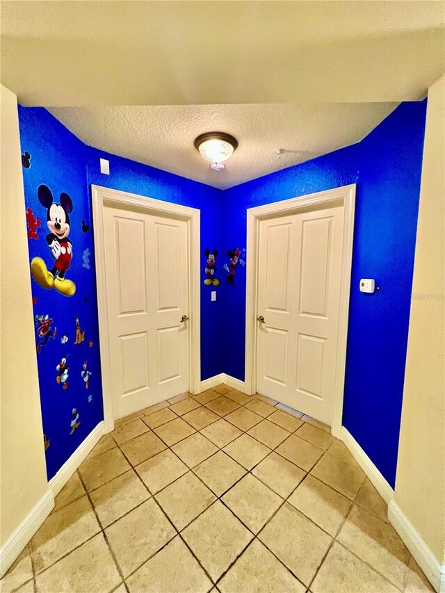 tiled foyer entrance featuring a textured ceiling