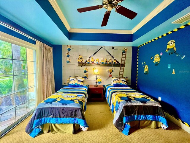 carpeted bedroom with ornamental molding, ceiling fan, and a tray ceiling