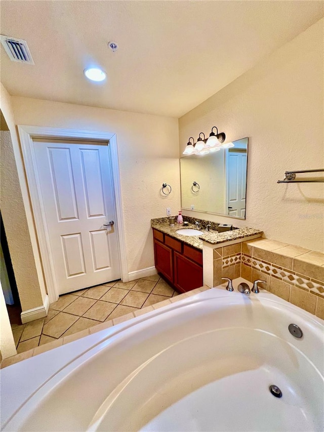 bathroom with a bathtub, vanity, and tile floors