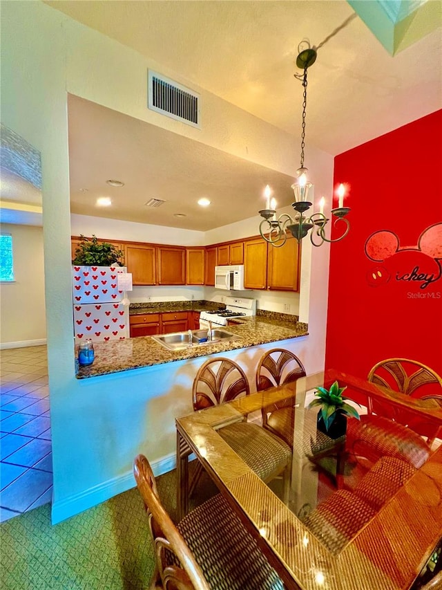 tiled dining room featuring sink and a chandelier