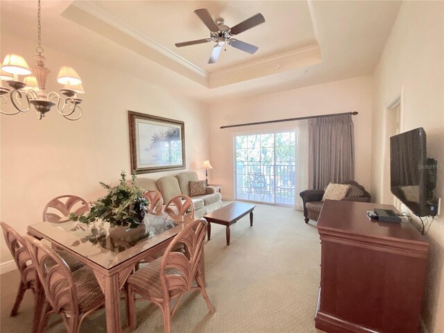 interior space featuring carpet, a raised ceiling, and ceiling fan with notable chandelier