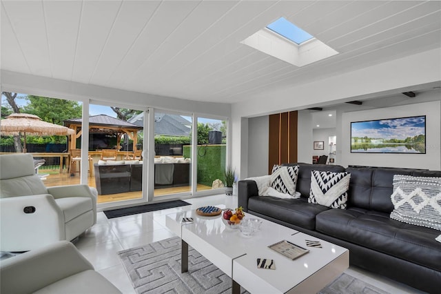 tiled living room featuring a skylight and wooden ceiling