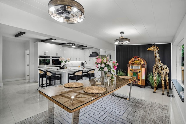 dining room featuring ceiling fan and sink