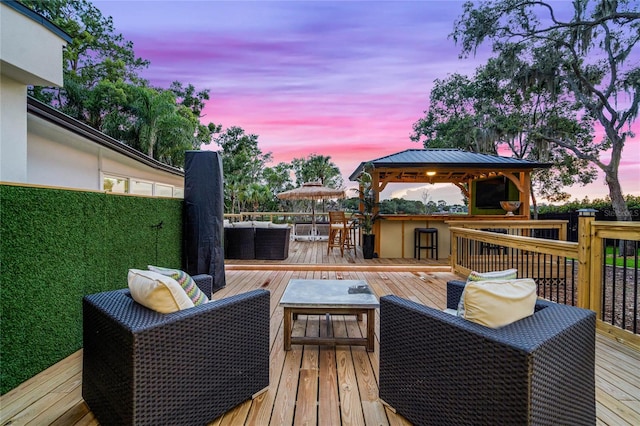 deck at dusk featuring outdoor lounge area, a gazebo, and a bar