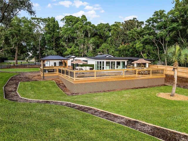 back of property featuring a lawn and a wooden deck