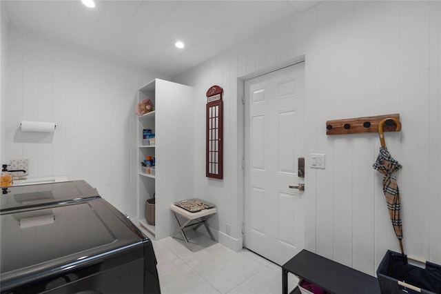 laundry area with washer and clothes dryer and light tile patterned flooring