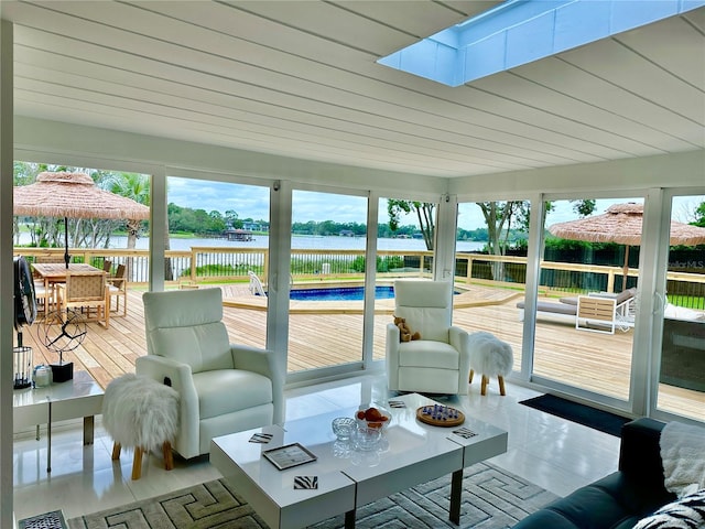 sunroom with a skylight, a water view, and a healthy amount of sunlight