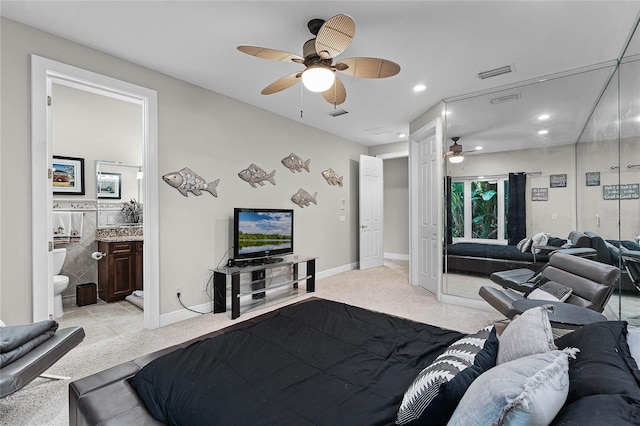 carpeted bedroom with ensuite bath and ceiling fan