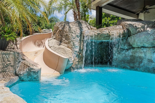 view of pool with pool water feature and ceiling fan