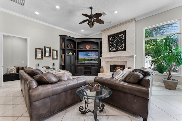 living room featuring crown molding, ceiling fan, light tile patterned floors, a textured ceiling, and a premium fireplace