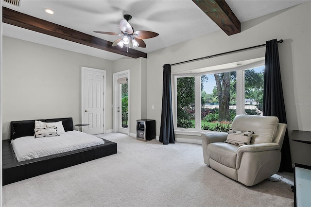 bedroom with ceiling fan, beamed ceiling, and light colored carpet