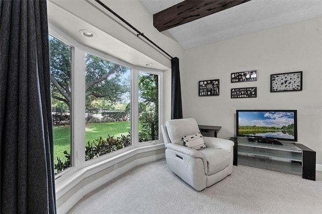 living area featuring carpet flooring, lofted ceiling with beams, and a healthy amount of sunlight