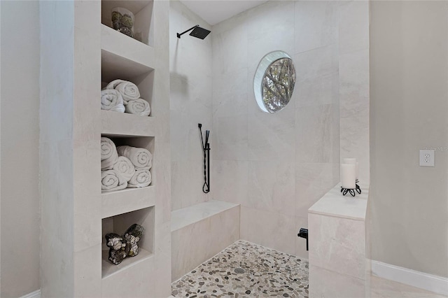 bathroom with tile patterned flooring and a tile shower