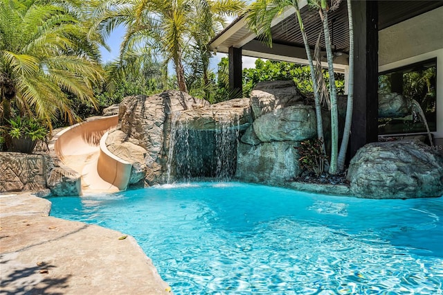 view of pool with pool water feature and a water slide