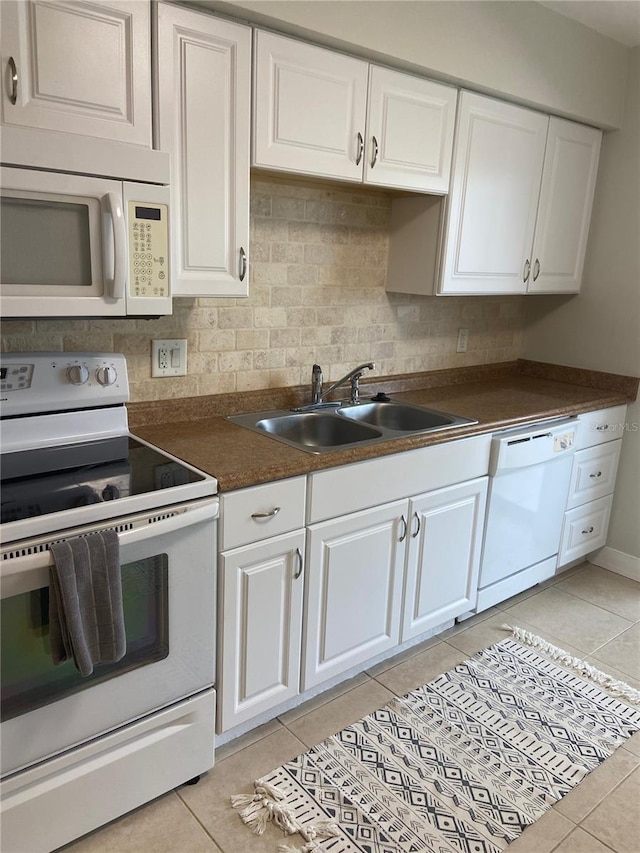 kitchen with white cabinets, light tile patterned flooring, white appliances, and sink