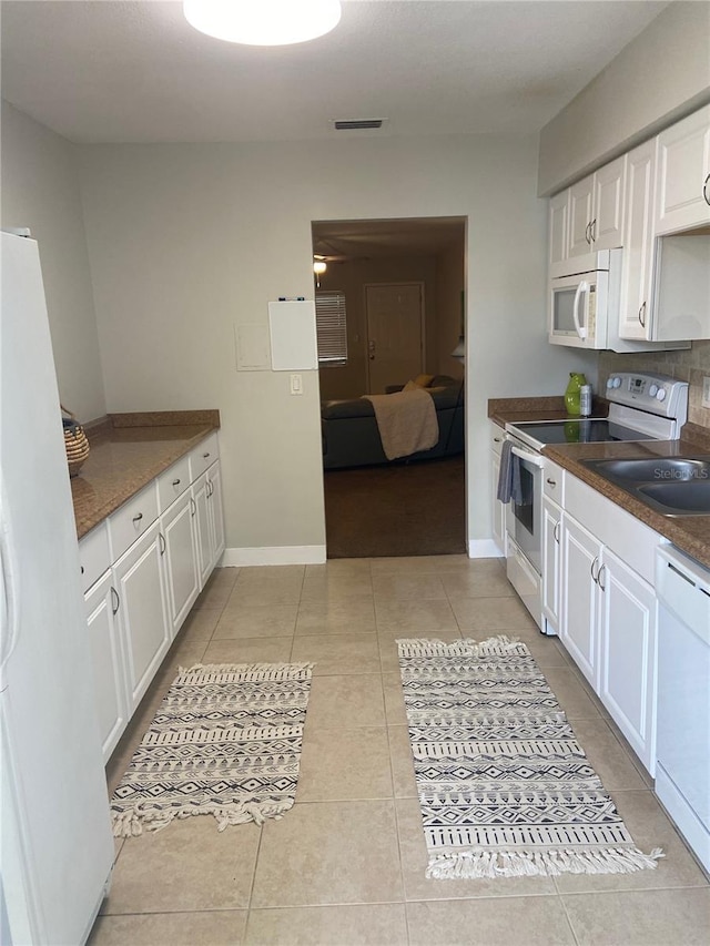 kitchen featuring white cabinetry, white appliances, and light tile patterned floors