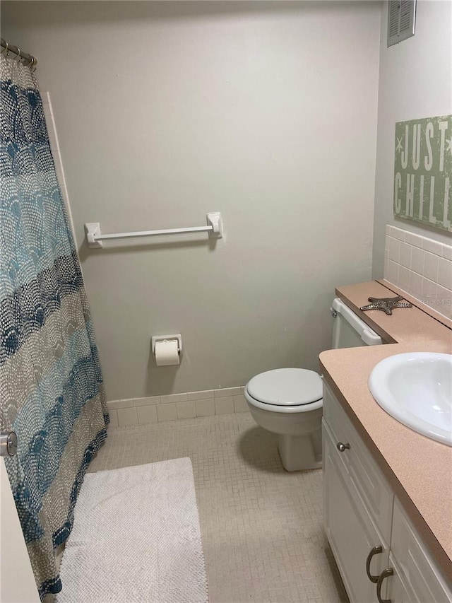 bathroom with tile patterned flooring, vanity, and toilet