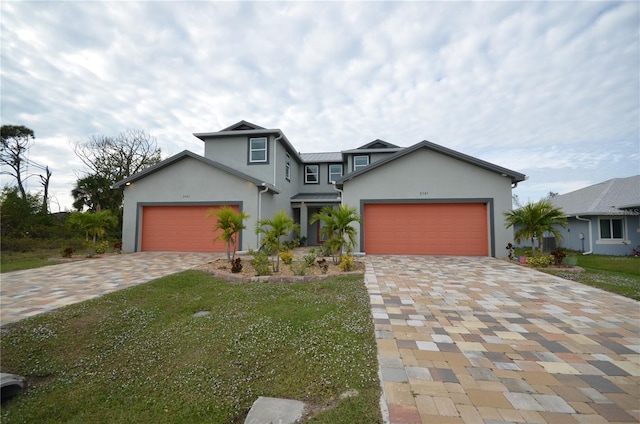 traditional home with stucco siding, an attached garage, decorative driveway, and a front yard