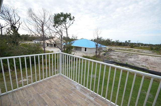 wooden deck featuring a lawn