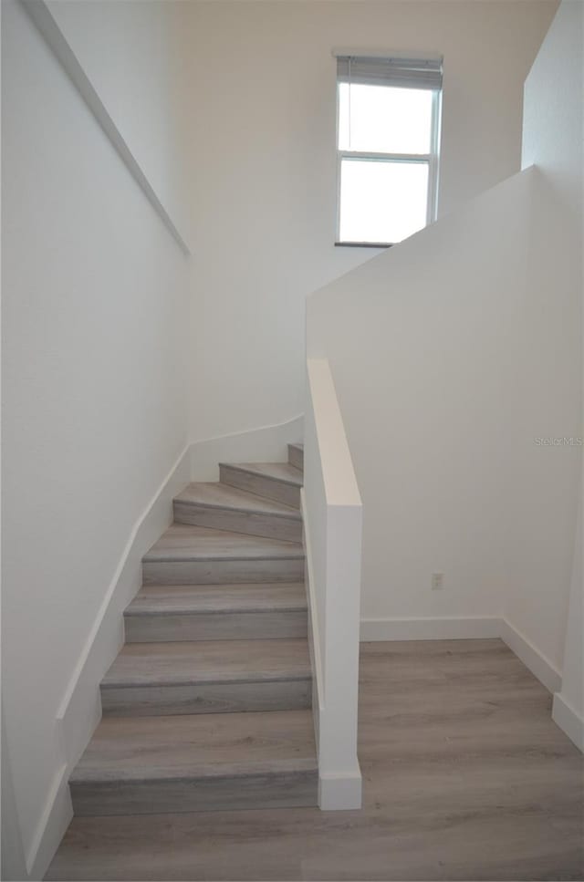 stairway featuring baseboards and wood finished floors