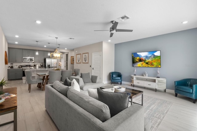 living room with ceiling fan and light hardwood / wood-style flooring