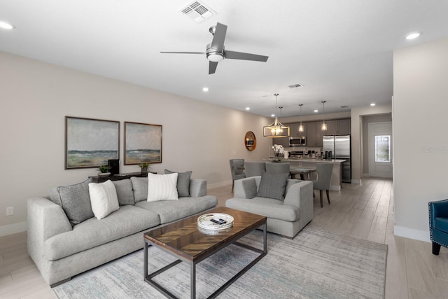 living room featuring ceiling fan and light hardwood / wood-style floors