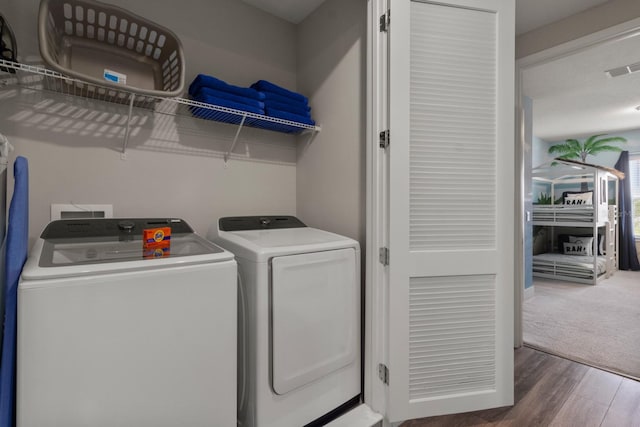 laundry room featuring dark hardwood / wood-style flooring and washer and clothes dryer