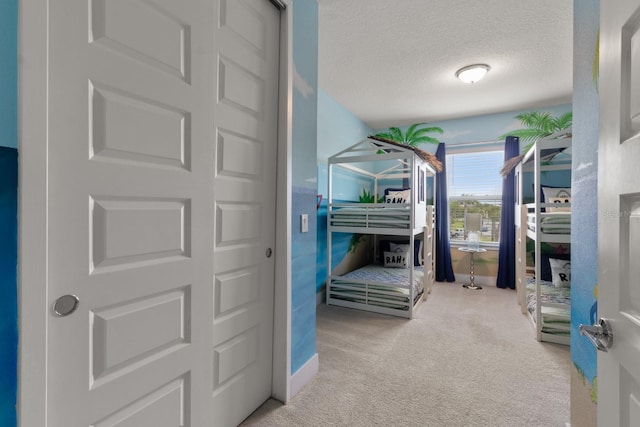 bedroom featuring light colored carpet and a textured ceiling