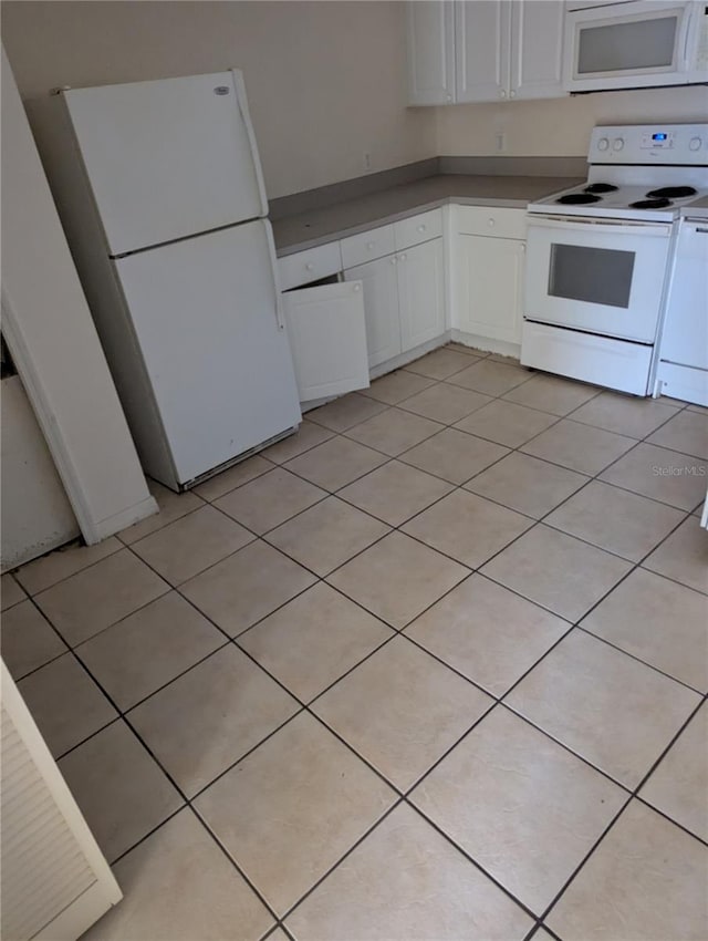 kitchen with white appliances, white cabinetry, and light tile patterned flooring