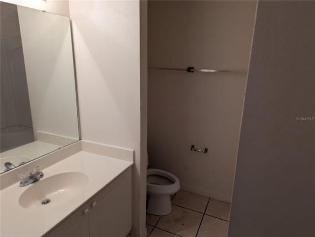 bathroom featuring toilet, vanity, and tile patterned floors