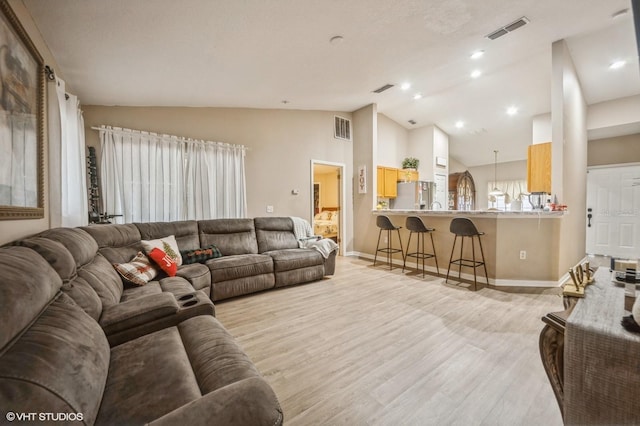 living room with light hardwood / wood-style floors and lofted ceiling