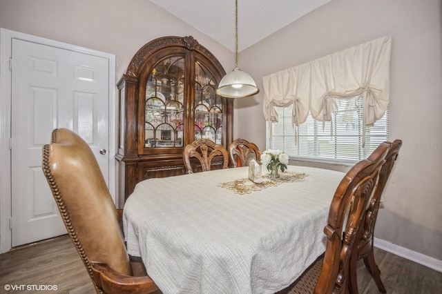 dining room with hardwood / wood-style flooring and lofted ceiling