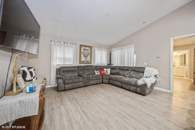 living room with vaulted ceiling and light wood-type flooring