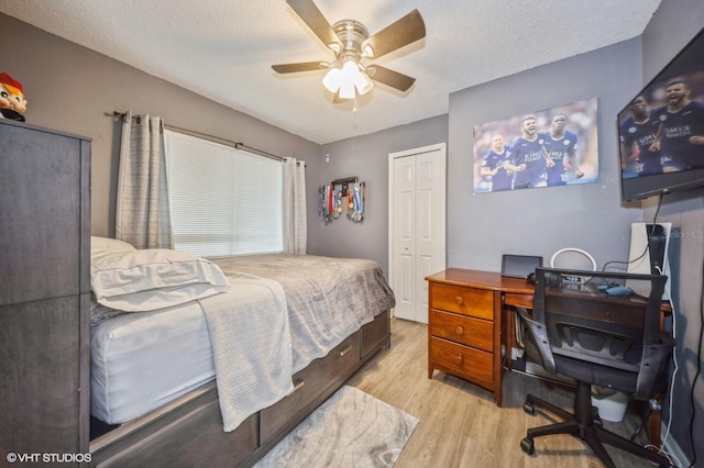 bedroom featuring ceiling fan, a closet, light hardwood / wood-style floors, and a textured ceiling