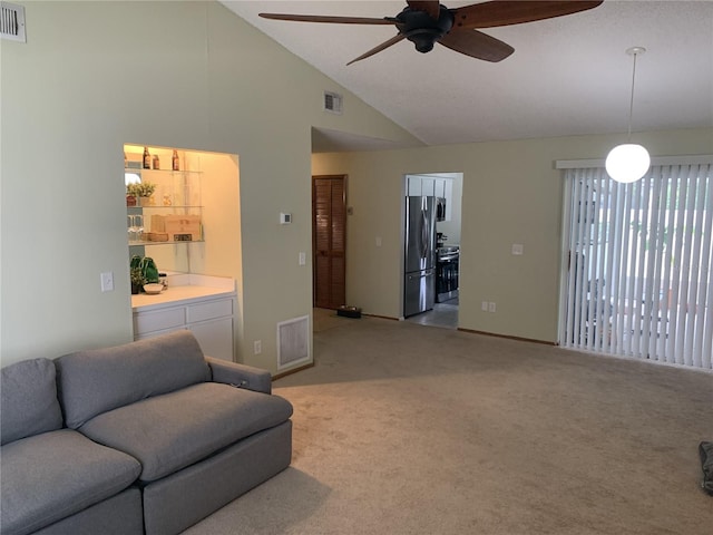 living room featuring carpet, ceiling fan, and vaulted ceiling